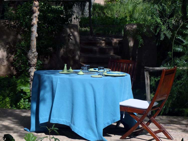 A table with blue cloth in preparation for a delicious meal.