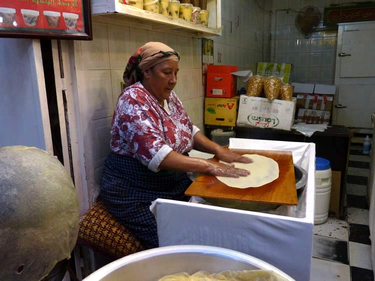 The cook rolls out the dough very thin.