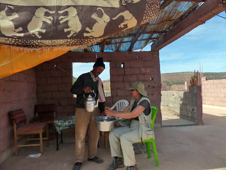 Open air dining with a beverage being served to a guest. 