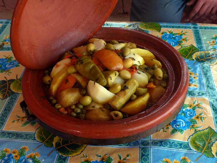 A rich stew in a red clay pot.