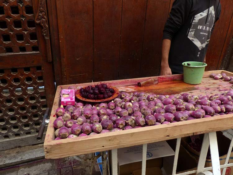 A market table filled with red onions.