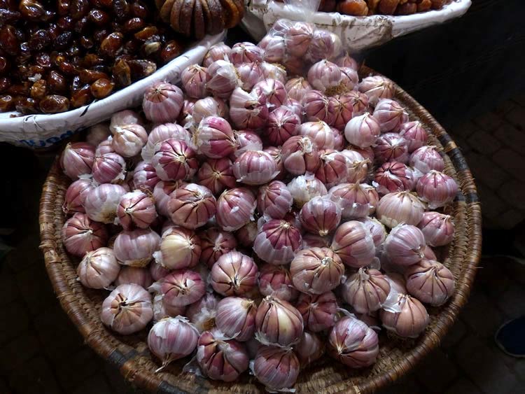 Large market baskets full of garlic and figs.