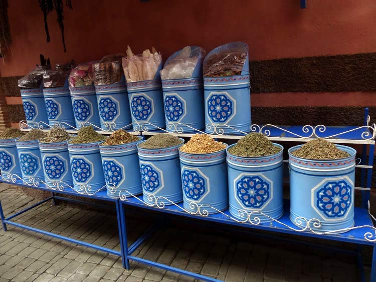 Rows of blue containers filled with dried pods and spices.