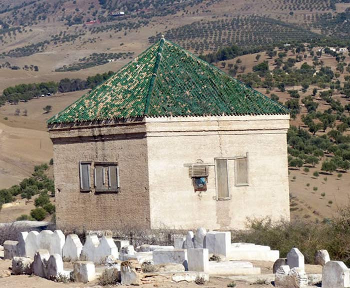 A white building with headstones around.