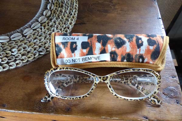 Bedside desk with cheetah patterned sunglasses..