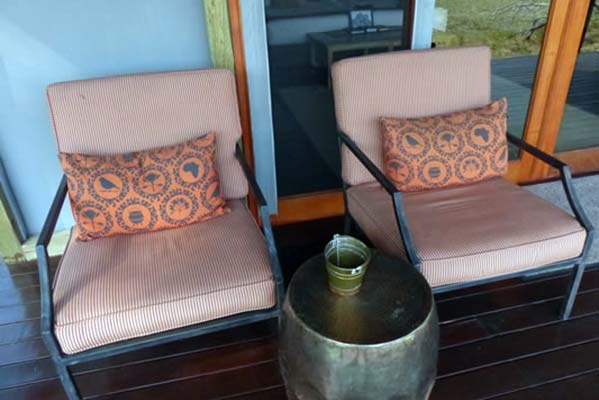 Chairs with patterned pillows outside the rooms.