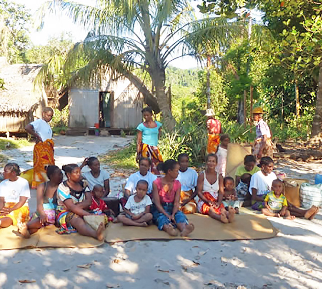 African community seated together on the ground.