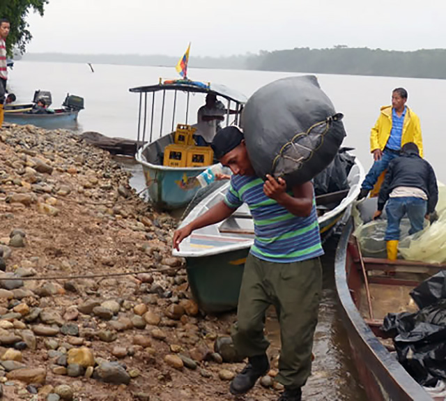 Fishermen with their boats and nets hauling their fish in to shore>