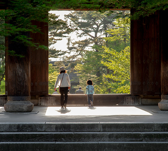 Family walking in a doorway to a beautiful green garden