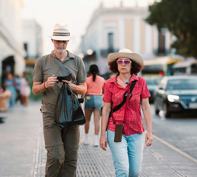 Couple in Hats Walking Sidewalk