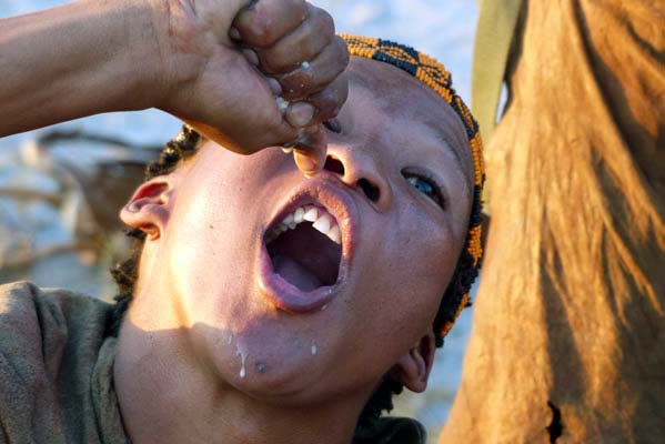 Young African boy with mouth wide open as if just finishing drinking a beverage.