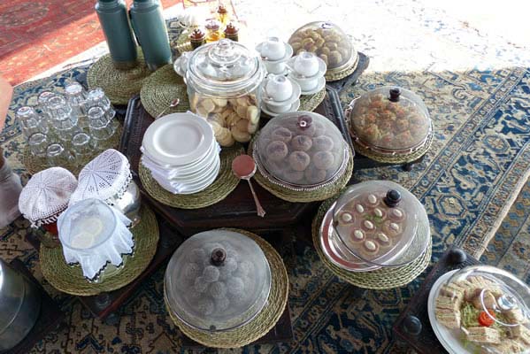 Platters of tea cakes, finger sandwiches, nuts, sweets and plates for tea on Safari.