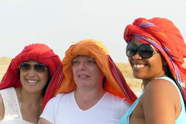 Three Safari travelers with colorful head coverings.