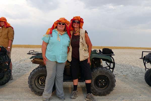 Two women travelers standing in front of their ATVs.