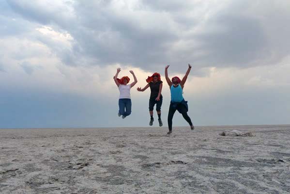 Three travelers jumping in the air.