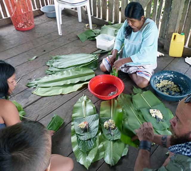 Latin American woman sitting on floor preparing a meal.