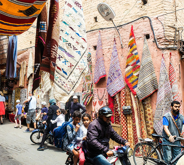 Boy and girl on motorcycle in the Marrakesh, Morocco market.