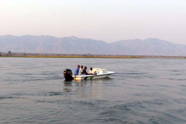 A speedboat with four African men on board.