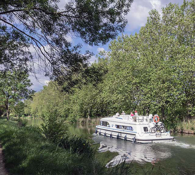  A boat on the Canal du Midi, UNESCO World Heritage Site, Vias, Hérault, France.