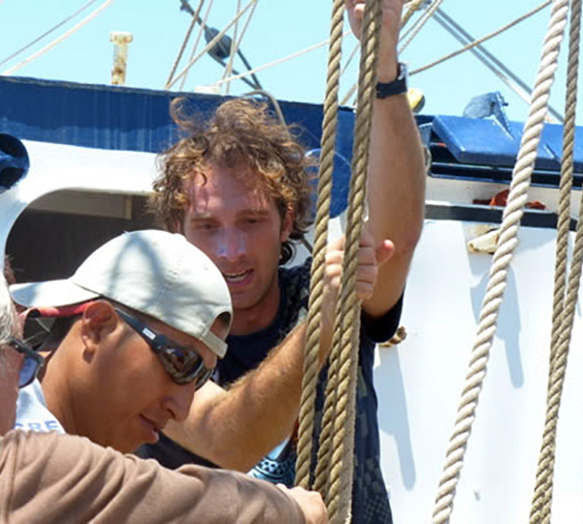 Crew aboard a small ship to the