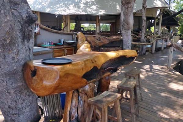 The trunk of a tree crafted into a table at the camp's bar.