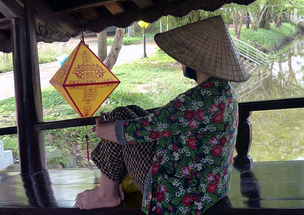 Thanh Toan Village. Thanh Toan Village, 17th century tile-roofed bridge with seated local resident. Women come to the bridge to gossip and chew the betle nut, which helps stimulate conversation.